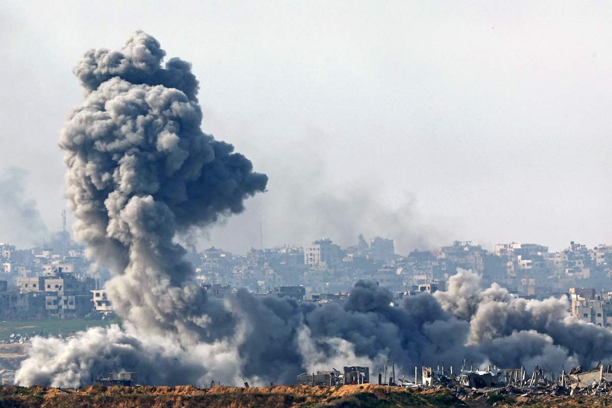Smoke plumes rise from explosions above destroyed buildings in the northern Gaza Strip on Jan. 14. (AFP)