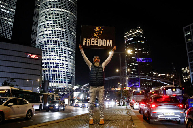 A man holds a placard on a road as supporters and family members of hostages kidnapped during the deadly October 7, 2023, attack on Israel by Hamas, protest ahead of a ceasefire between Israel and Hamas, in Tel Aviv, Israel, on January 16, 2025. (REUTERS)