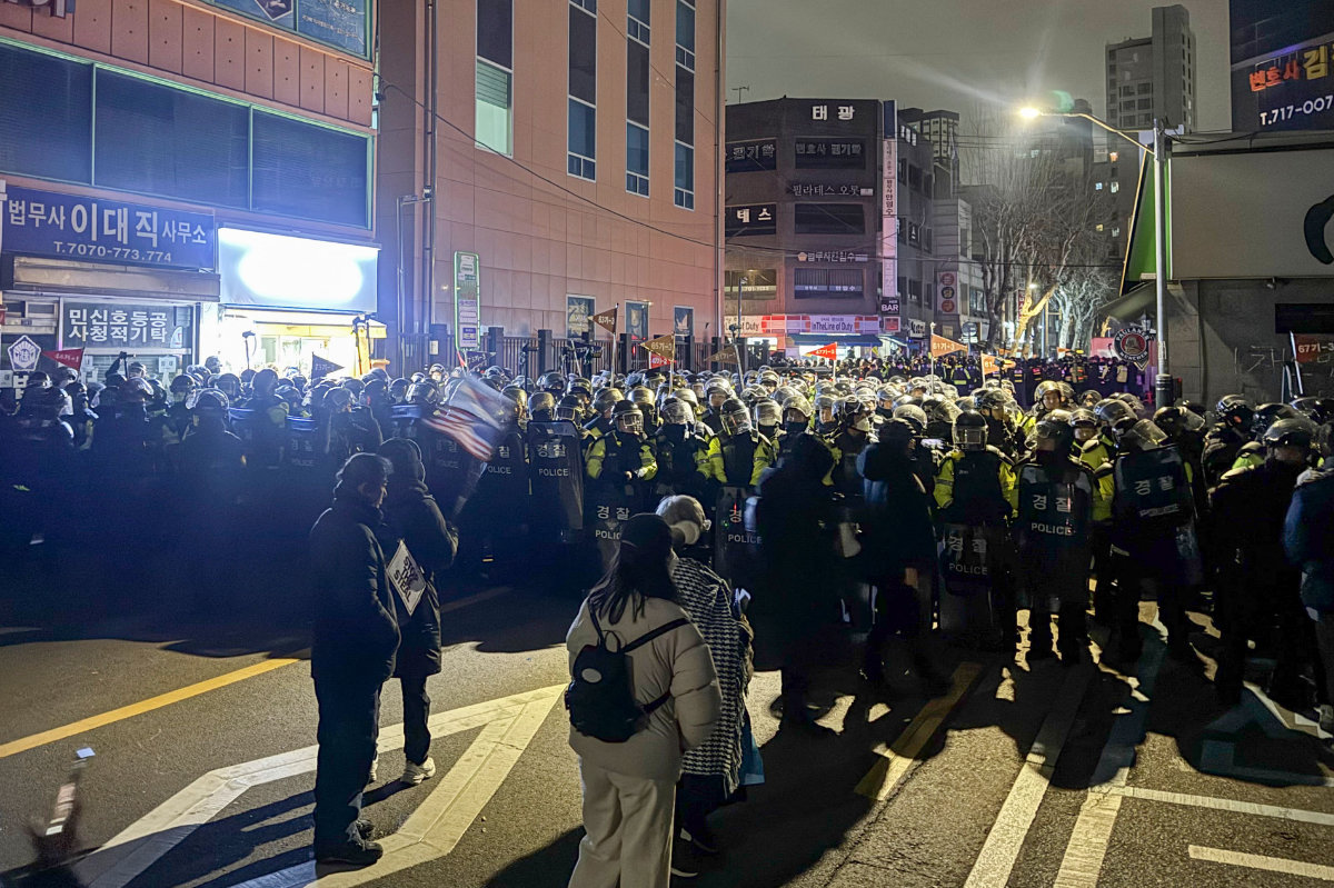 Police stand guard on a street near the Seoul Western District Court in Seoul early on January 19, 2025, after hundreds of protesters smashed windows and broke down doors to enter the court, which extended the detention of impeached South Korea President Yoon Suk Yeol. (AFP)