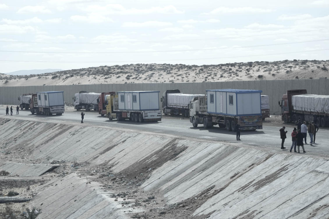 Truck drivers, transporting humanitarian aids, wait at the Baloza check point, on their way to cross the Rafah border crossing between Egypt and the Gaza Strip, Sunday, Jan. 19, 2025. (AP)