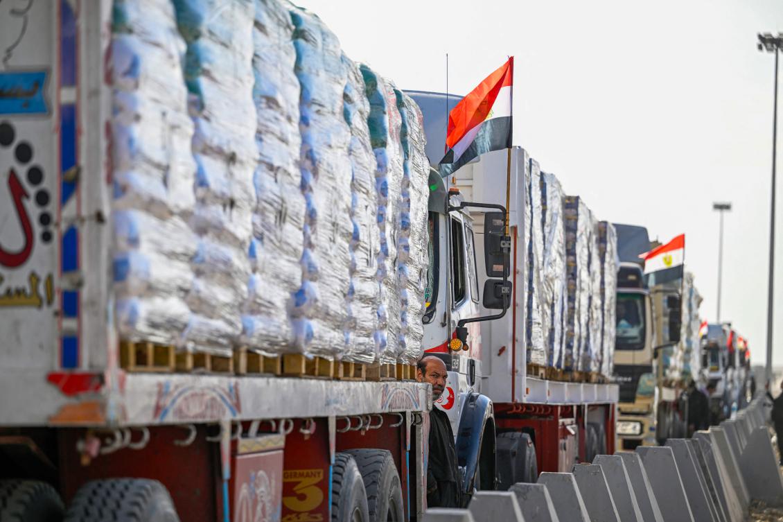 A driver waits next to trucks loaded with aid to cross into Gaza from the Egyptian side of the Rafah border crossing on Jan. 19. (AFP)