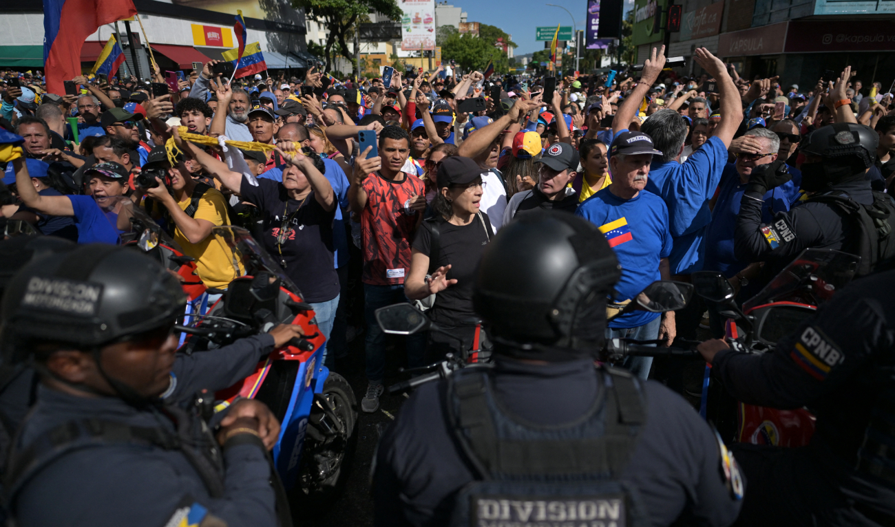 Demonstrators block members of police motorized division after Venezuelan opposition leader Maria Corina Machado delivered a speech during a protest called by the opposition on the eve of the presidential inauguration, in Caracas on January 9, 2025. (AFP/File)