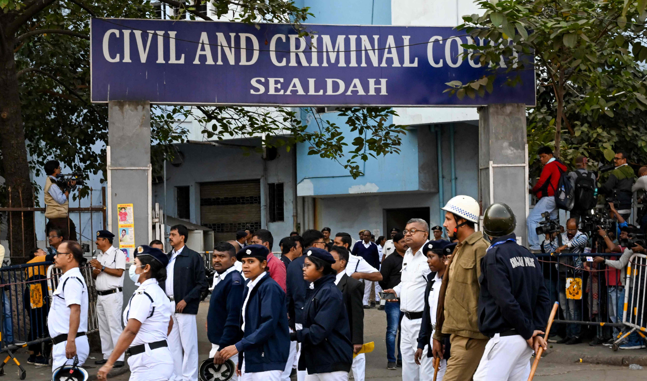 Police personnel stand guard at an entrance of Civil and Criminal Court Sealdah during the trial for the accused of rape and murder of an Indian doctor in Kolkata on January 18, 2025. (AFP)