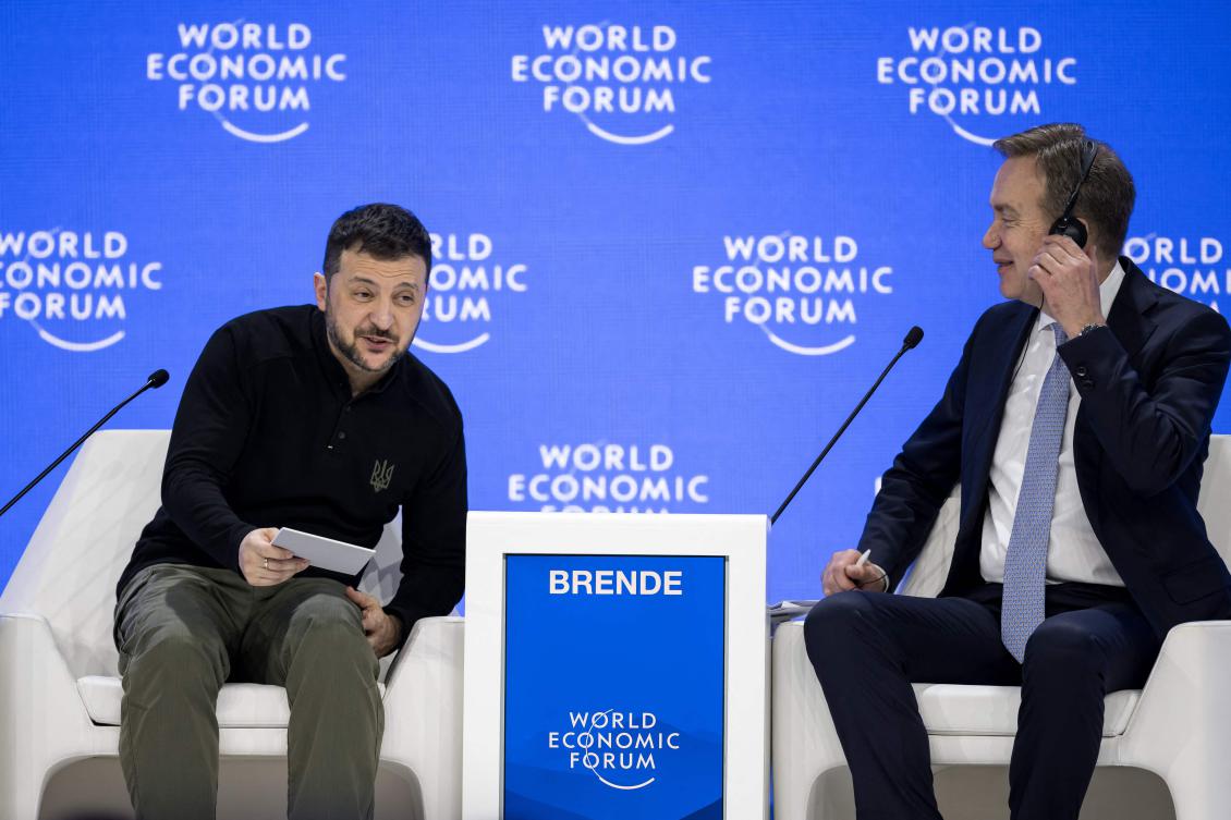 Ukraine’s President Volodymyr Zelensky leans over as World Economic Forum President and CEO Borge Brende watches him, during the WEF annual meeting in Davos on Jan. 21, 2025. (AFP)