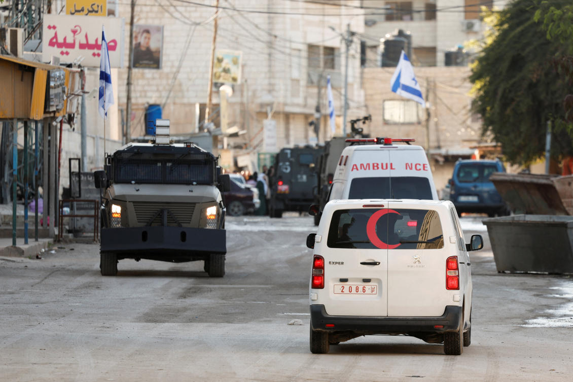 An ambulance and an Israeli military vehicle drive on the street during an Israeli raid, in Jenin, in the Israeli-occupied West Bank, Jan. 21, 2025. (Reuters)