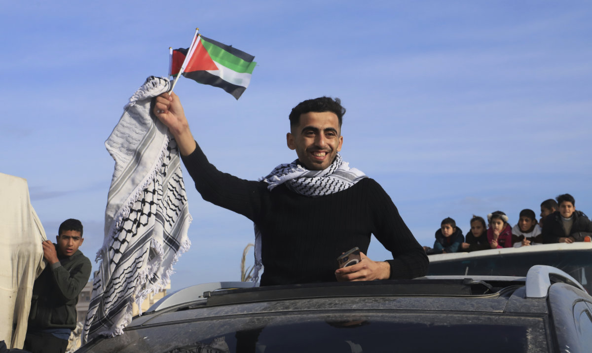 A man waves a Palestinian flag as he returns home to Rafah, after a ceasefire deal between Israel and Hamas went into effect, in Rafah, Gaza Strip, Jan. 19, 2025. (AP)