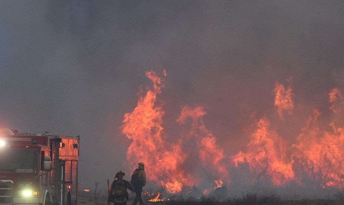 Firefighters light backfires near power lines as smoke from the Hughes Fire fills the sky in Castaic, a northwestern neighborhood of Los Angeles, California, January 22, 2025. (AFP)