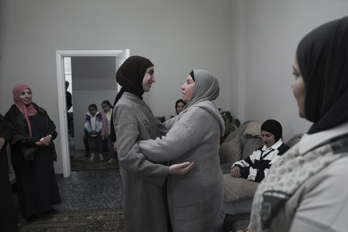 Amal Shujaeiah, a former Palestinian prisoner who was released from an Israeli prison as part of a ceasefire deal between Israel and Hamas, embraces relatives at her home in Dayr Jarir, West Bank, Monday, Jan. 20, 2025. (AP)