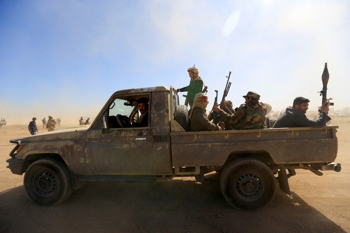 Huthi fighters ride a military vehicle (AFP)