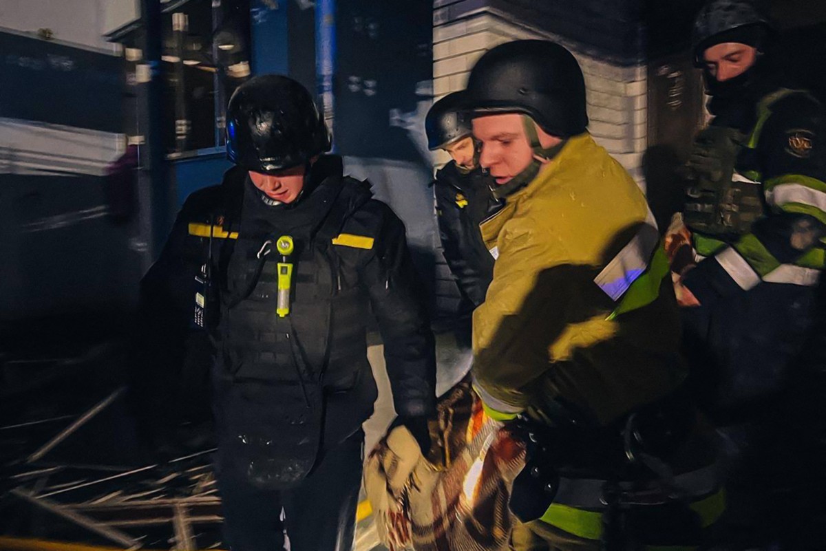In this handout photograph taken and released by the Ukrainian Emergency Service on January 24, 2025, Ukrainian rescuers carry the body of a killed person at the site of a missile attack in Kyiv region. (AFP)