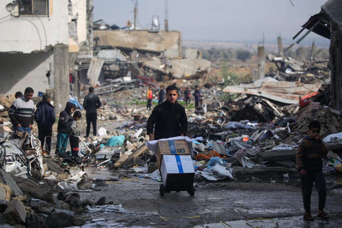 A Palestinian youth hauls food aid parcels received at a distribution point in Bureij in the central Gaza Strip on Jan. 23, 2025. (AFP)