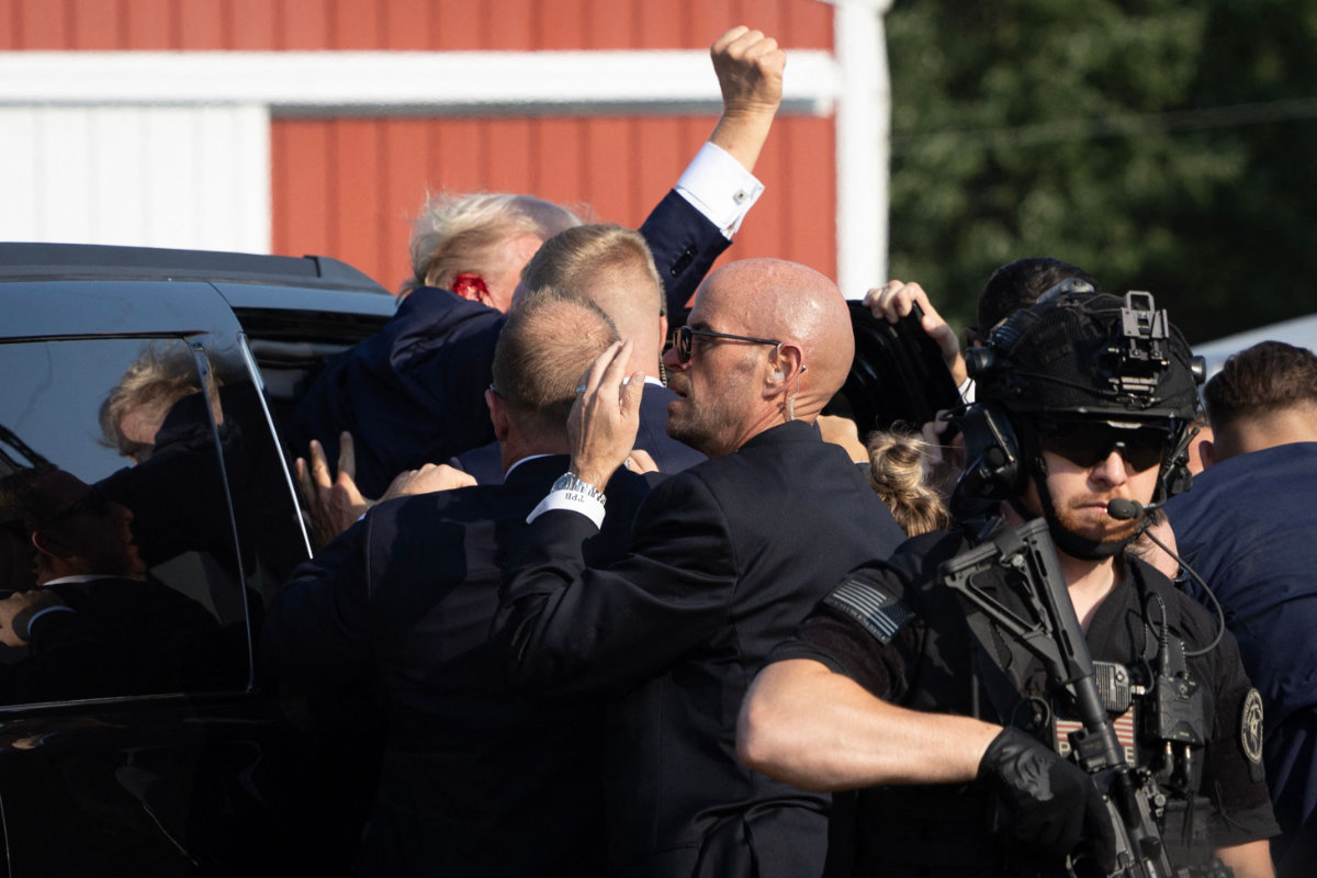 In this photo taken on July 13, 2024, Republican presidential candidate Donald Trump is rushed offstage after being shot during a campaign rally in Butler, Pennsylvania. On Friday, a man was arrested by US authorities after threatening to kill the newly installed US president. (Getty Images via AFP)