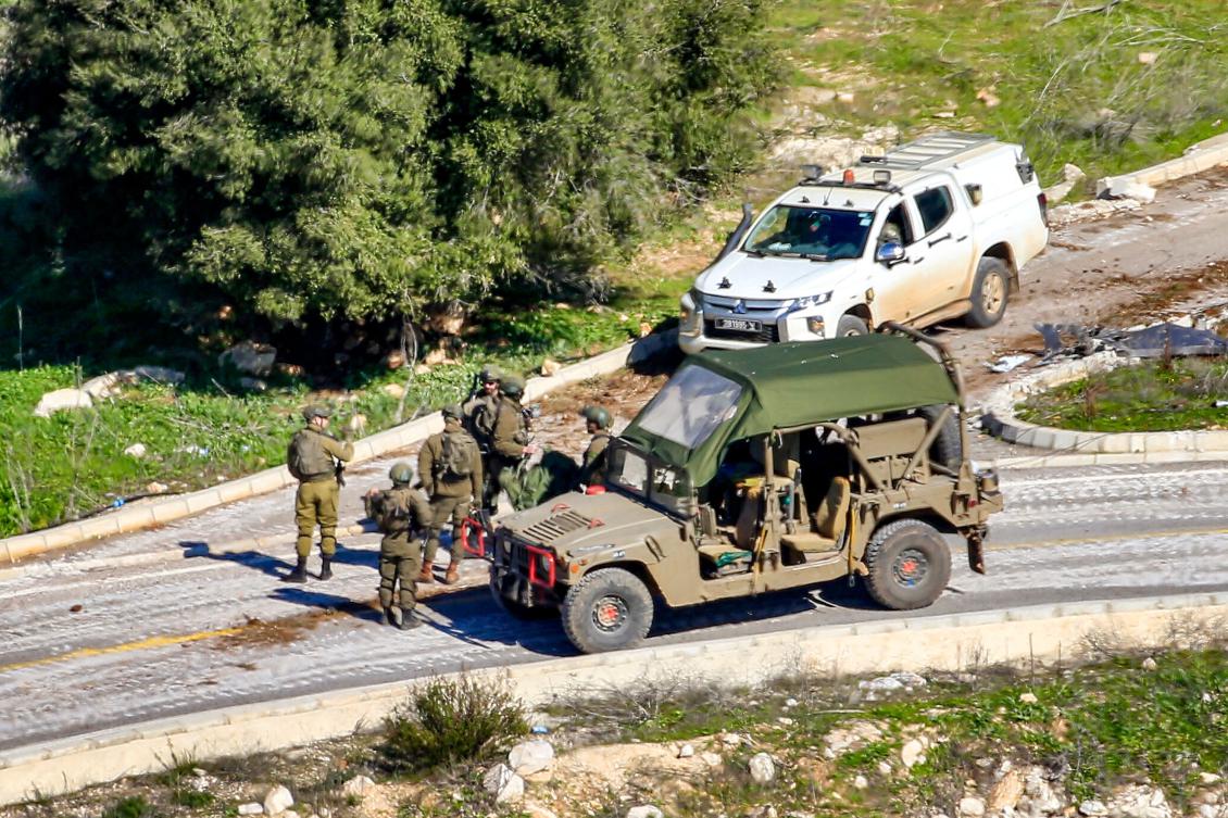 This picture taken from Lebanon’s southern village of Shaqra on Jan. 25, 2025 shows Israeli army soldiers by a humvee and a four-wheel-drive vehicle at the entrance of the village of Hula along the border with Israel in south Lebanon. (AFP)