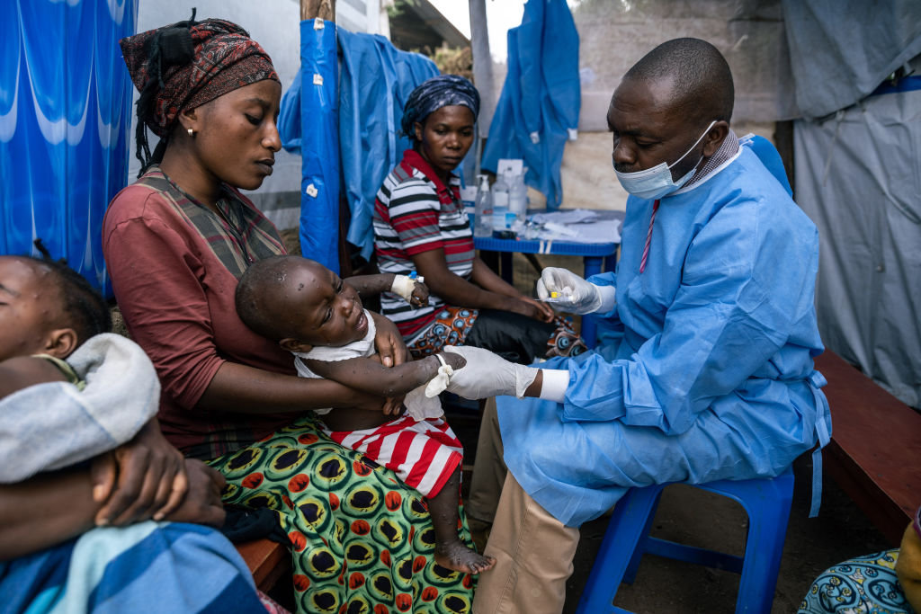 A mother holds her son as he receives his daily injection while being treated for mpox at the Kavumu health center in Kabare territory, South Kivu region, DR Congo, on Tuesday, Sept. 3, 2024. (Bloomberg via Getty Images)