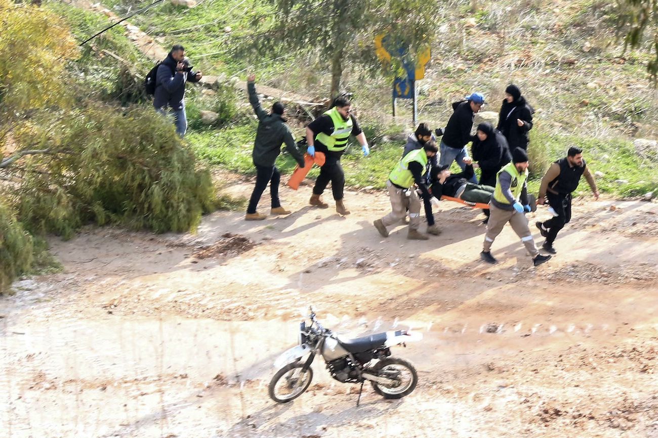 Rescuers in Chaqra carry an injured person shot by Israeli soldiers after he allegedly tried to walk toward Mais Al-Jabal in southern Lebanon on Jan. 26, 2025. (AFP)