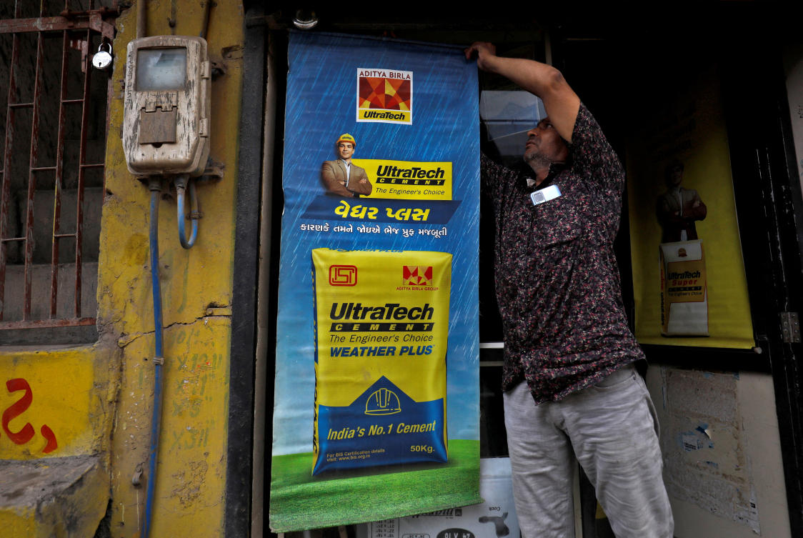 FILE PHOTO: A man installs an UltraTech Cement billboard at his shop in Ahmedabad, India, July 28, 2022. (Reuters)