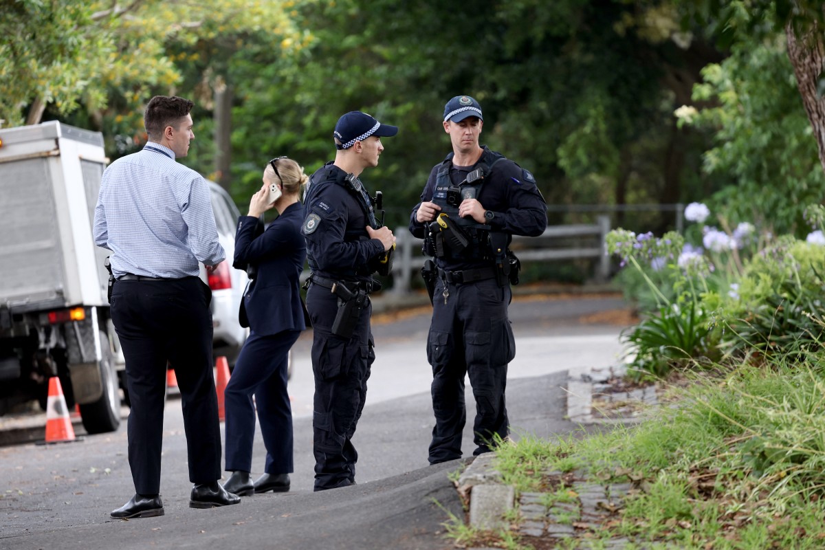 Police officers and detectives inspect the area where anti-Israel graffiti was written on a wall in the Sydney suburb of Woollahra on December 11, 2024. (AFP)