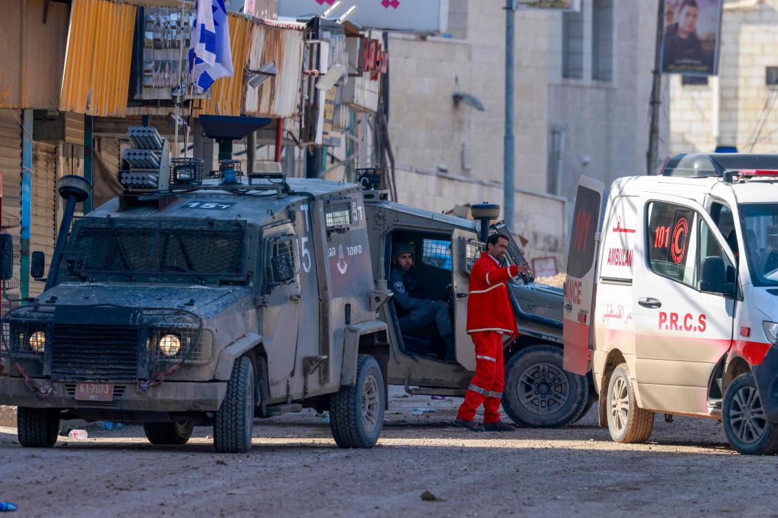 Israeli soldiers speak with a Palestinian paramedic during a raid on the Jenin camp for Palestinian refugees in the Occupied West Bank, Jan. 27 (AFP)