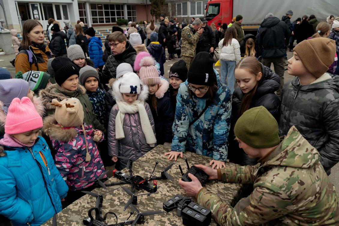 A Ukrainian serviceman shows children FPV drones piloting skills during the opening of the 65th Brigade’s recruiting center “Velykyi Lug” in Kyiv on Jan. 27, 2025. (AFP)