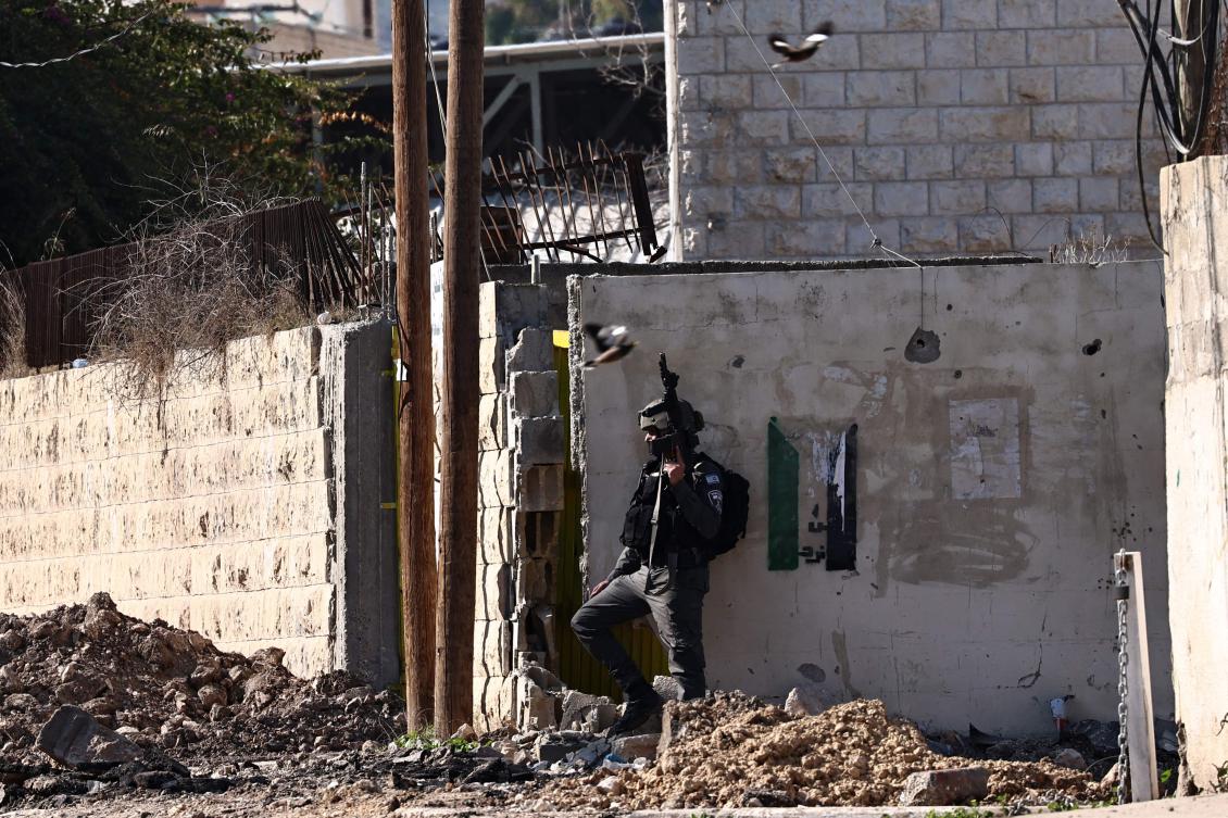 An Israeli soldier stands behind a wall during a military raid in Jenin, occupied West Bank, Jan. 29, 2025. (AFP)