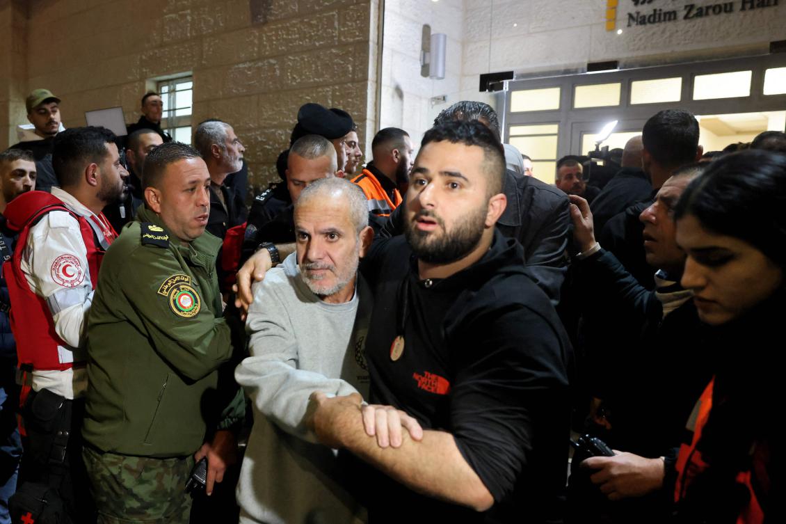 A crowd welcomes Palestinians formerly jailed by Israel as they arrive in a Red Cross convoy to Ramallah in the occupied West Bank on Jan. 30, 2025. (AFP)