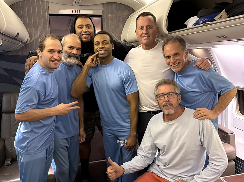US President Donald Trump's Special Missions Envoy Richard Grenell (3rd R) posing on board a plane alongside six US citizens released from detention in Venezuela. (Richard Grenell/AFP)