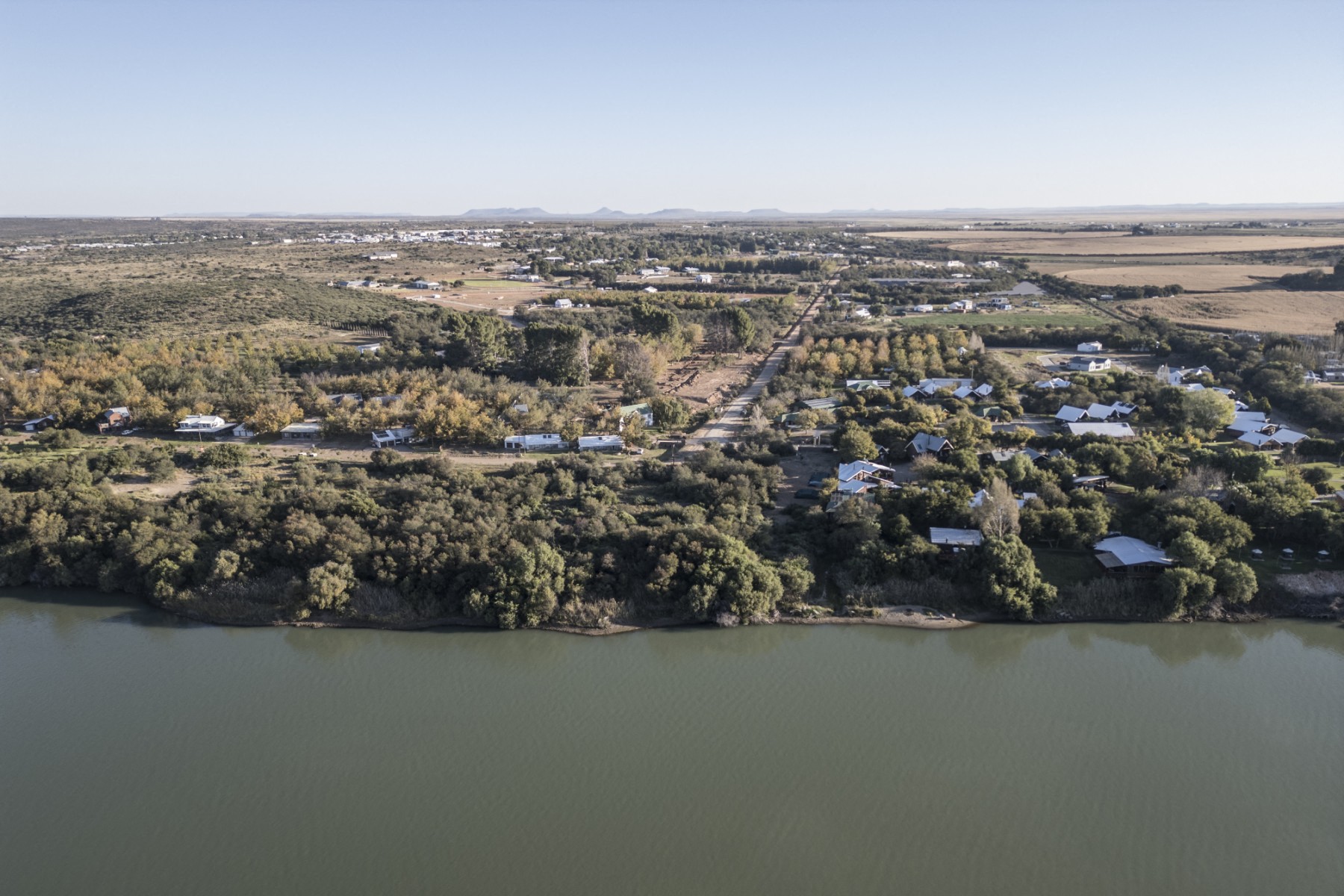 This aerial view shows agricultural land (R), the Orange River and Orania, on May 26, 2024 (AFP)