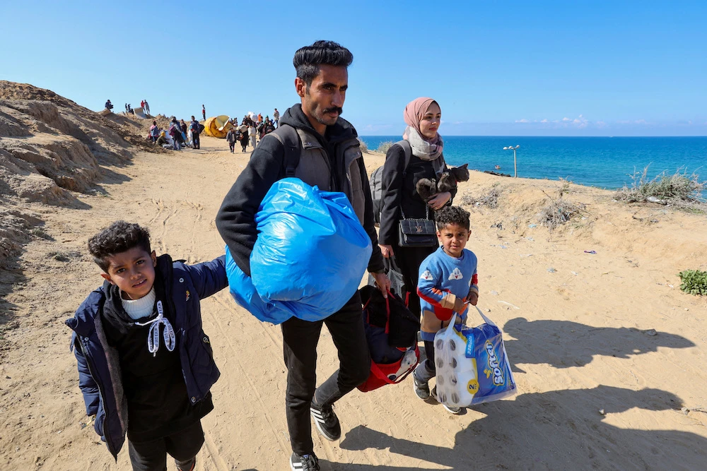 A Palestinian family walks with other Palestinians to return to their homes in northern Gaza on Jan. 27, 2025. (Reuters)