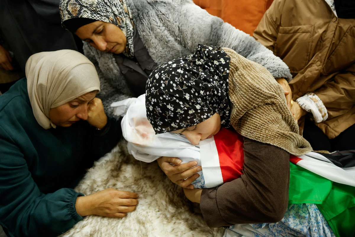 Mother of two-year-old who was killed during Israeli raid embraces the body of her daughter, near Jenin. (Reuters)