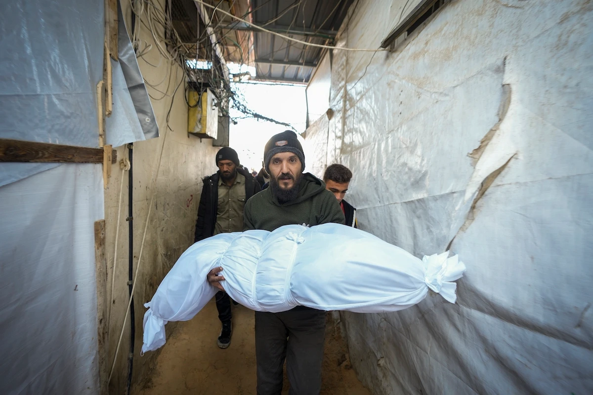 The body of a victim of an Israeli army strike on a house in the Bureij refugee camp is carried for the funeral at the Al-Aqsa Martyrs Hospital in the central Gaza Strip on Jan. 1. (AP)
