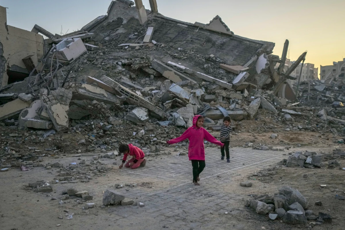 Palestinian children play next to a building destroyed by Israeli army strikes in the central Gaza Strip town of Khan Younis on Jan. 1, 2025. (AP)