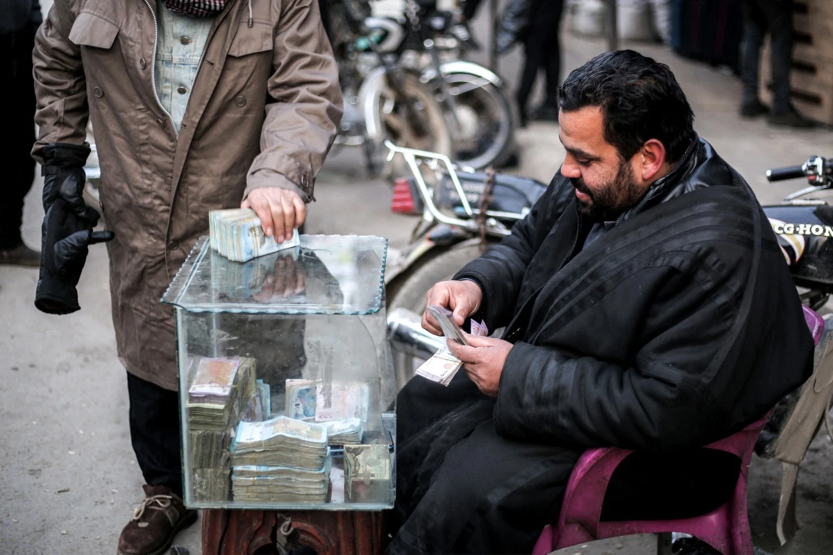 A currency trader sits at his stall at a market in the city of Manbij, currently controlled by the Turkish-backed Syrian National Army faction, in Syria's northern Aleppo province on January 4, 2025 (AFP)