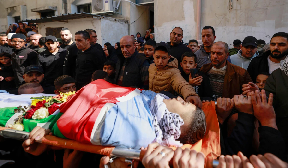 Mourners carry the body of Palestinian Mutaz Almadni, 18, who was killed at night in an Israeli army raid in Askar refugee camp, outside Nablus in the occupied West Bank, on January 6, 2025. (AFP)