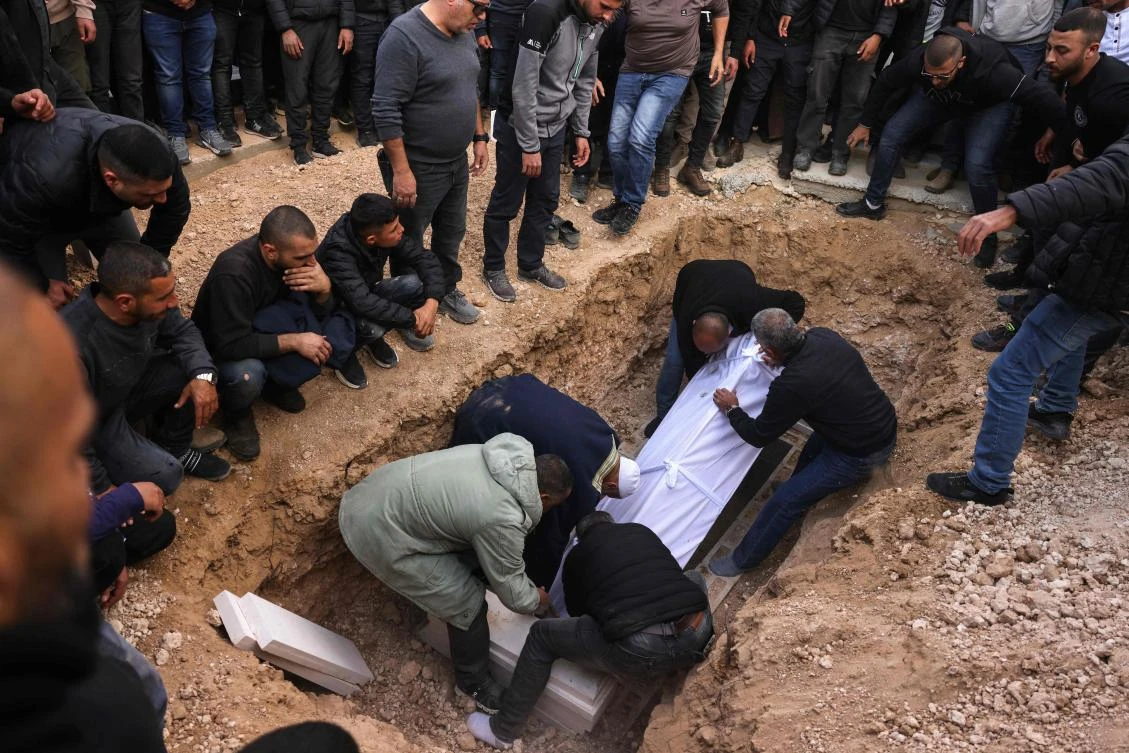 Relatives and friends of Israeli hostage Hamza Al-Zayadna, 22, lay his coffin in a grave during his funeral in Israel’s southern bedouin city of Rahat on Jan. 10, 2025. (AFP)