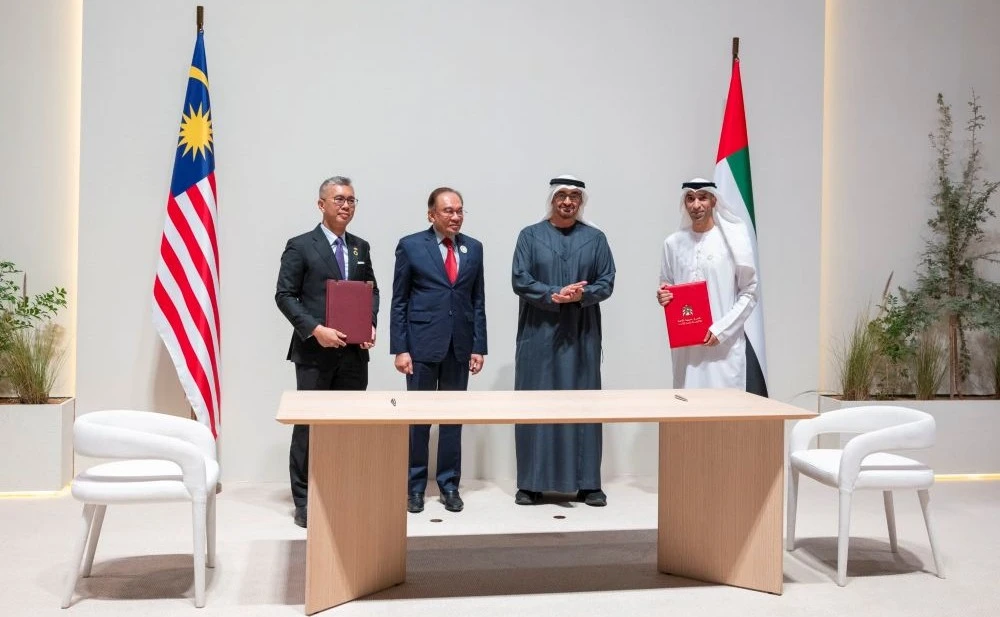 Malaysian PM Anwar Ibrahim and UAE President Sheikh Mohamed bin Zayed Al-Nahyan witness the signing of a Comprehensive Economic Partnership Agreement in Abu Dhabi on Jan. 14, 2025. (WAM)