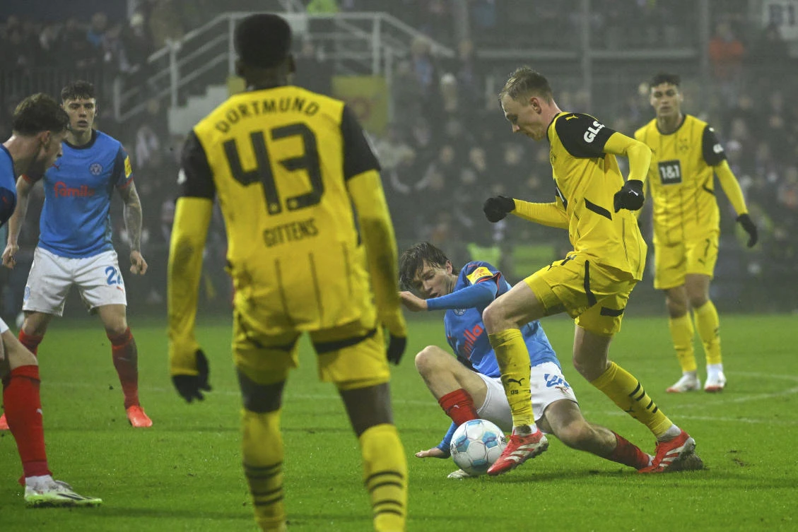 Kiel’s Magnus Knudsen, center, and Dortmund’s Maximilian Beier, second from right, challenge for the ball during their Bundesliga match at the Holstein Stadium in Kiel, Germany, Jan. 14, 2025. (AP)