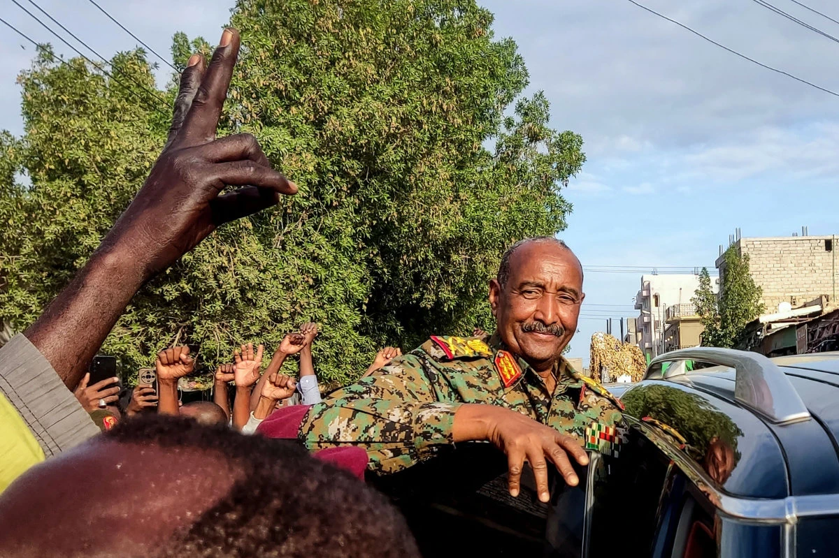 People gather to greet Sudan's army chief Abdel Fattah al-Burhan, along a street in Port Sudan, on January 14, 2025. (AFP)