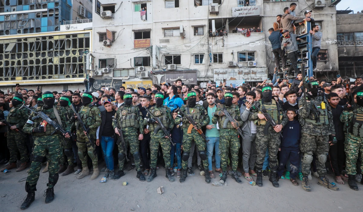 Fighters from the Qassam Brigades, the military wing of Hamas, control the crowd as Red Cross vehicles manoeuvre to collect Israeli hostages to be released under a ceasefire agreement between Israel and Hamas, in Gaza City, Sunday, Jan. 19, 2025. (AP)