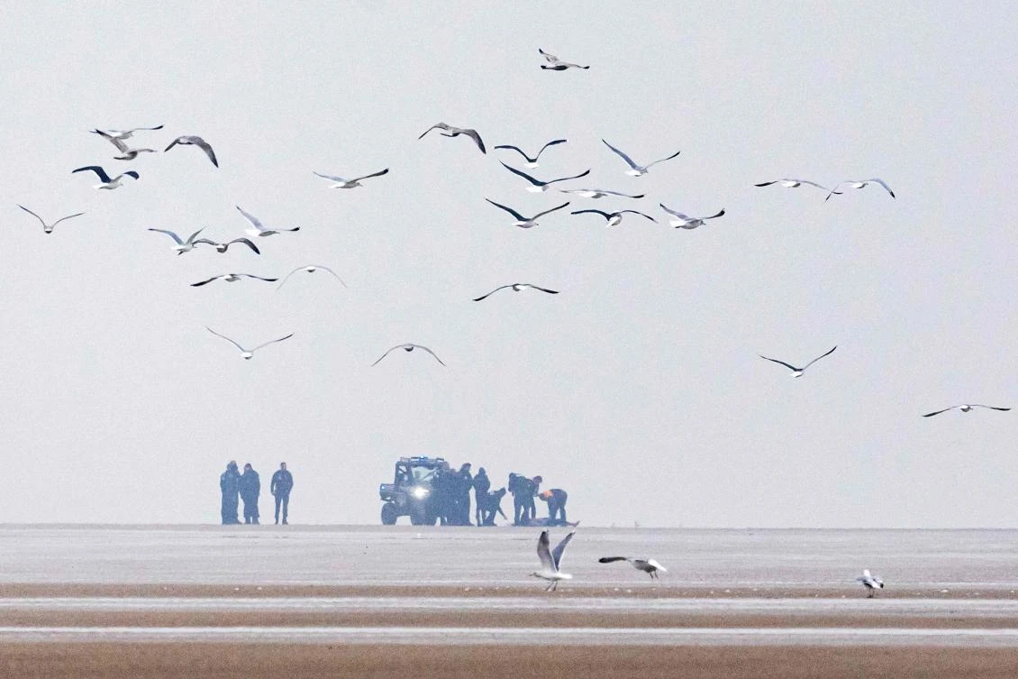 French National Police and French Republican Security Corps police officers stand next to a body discovered early morning on the beach of Sangatte, near Calais from where many migrants attempt the perilous English Channel crossing, northern France on Jan. 22, 2025. (AFP)