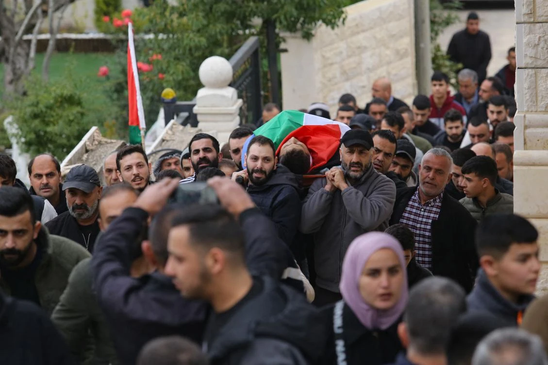 Mourners carry the flag-draped body of Ahmad Al-Shayb, a day after he was killed during an Israeli military raid on the occupied-West Bank town of Burqin west of Jenin, during his funeral on January 22, 2025. (AFP)