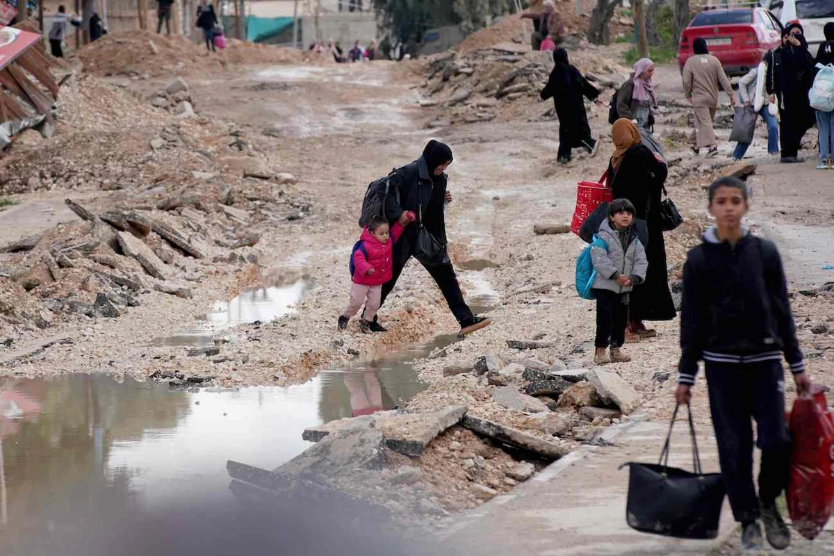 People carrying their belongings use a street previously destroyed by Israeli forces as they flee the Jenin refugee camp in the occupied West Bank on January 23, 2025. (AFP)