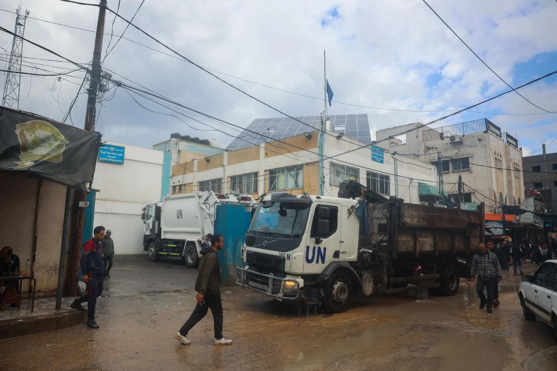 Palestinians walk in front of an UNRWA office in Bureij in the central Gaza Strip on Jan. 23, 2025, days into a ceasefire deal in the war between Israel and Hamas. (AFP)