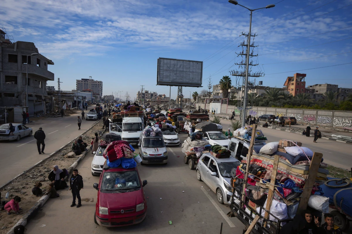 Displaced Palestinians with their belongings gather near a roadblock on Salah al-Din Street as they wait to return to their homes in the northern part of the Gaza Strip on Jan. 26, 2025, days after the ceasefire deal between Israel and Hamas came into effect. (AP)