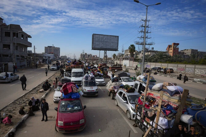 Displaced Palestinians with their belongings gather near a roadblock on Salah Al-Din Street as they wait to return to their homes in the northern part of the Gaza Strip on January 26, 2025. (AP)