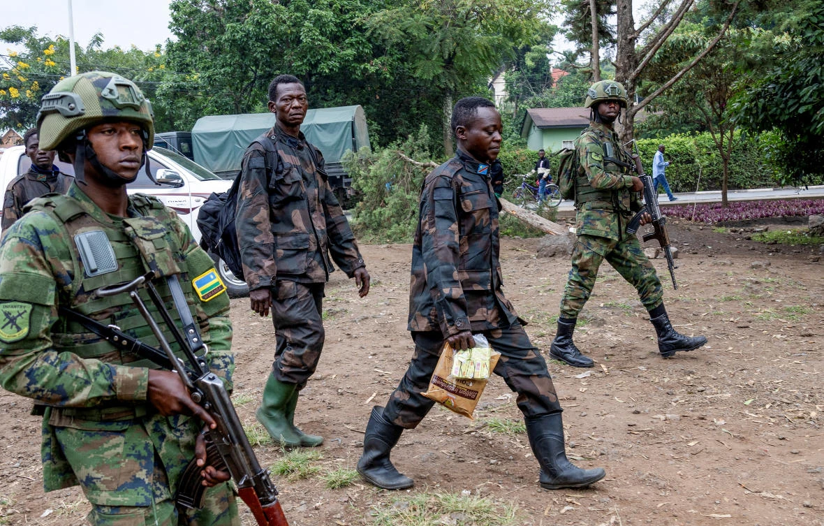 Rwandan security officers escort members of the Armed Forces of the Democratic Republic of the Congo (FARDC), who surrendered in Goma, eastern Democratic Republic of Congo following fighting between M23 rebels and the FARDC, in Gisenyi, Jan. 27, 2025. (Reuters)