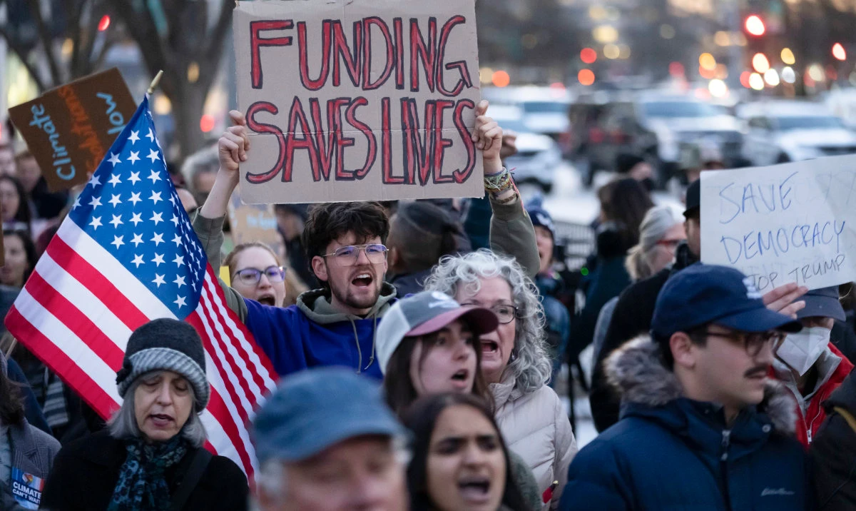 People protest against a funding freeze of federal grants and loans following a push from President Donald Trump to pause federal funding near to the White House in Washington, Tuesday, Jan. 28, 2025. (AP)