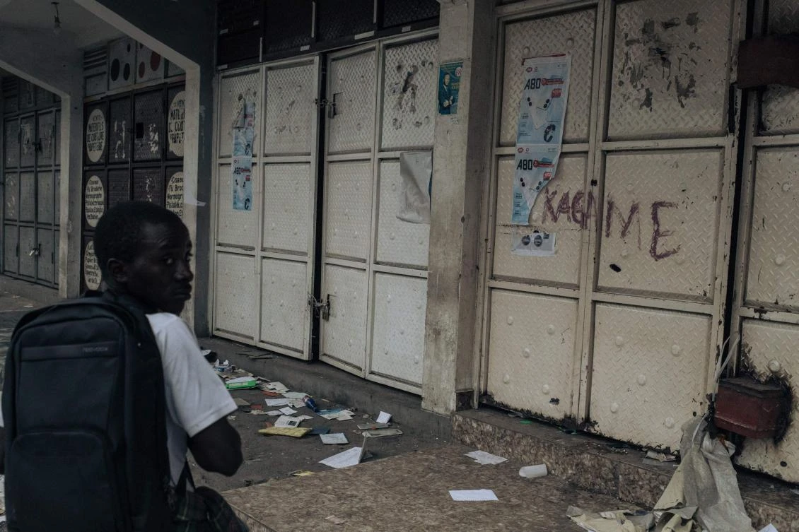 A resident walks past looted shops, with the name of the Rwandan president ‘Kagame’ written on a door, following clashes in Goma on January 30, 2025. (AFP)
