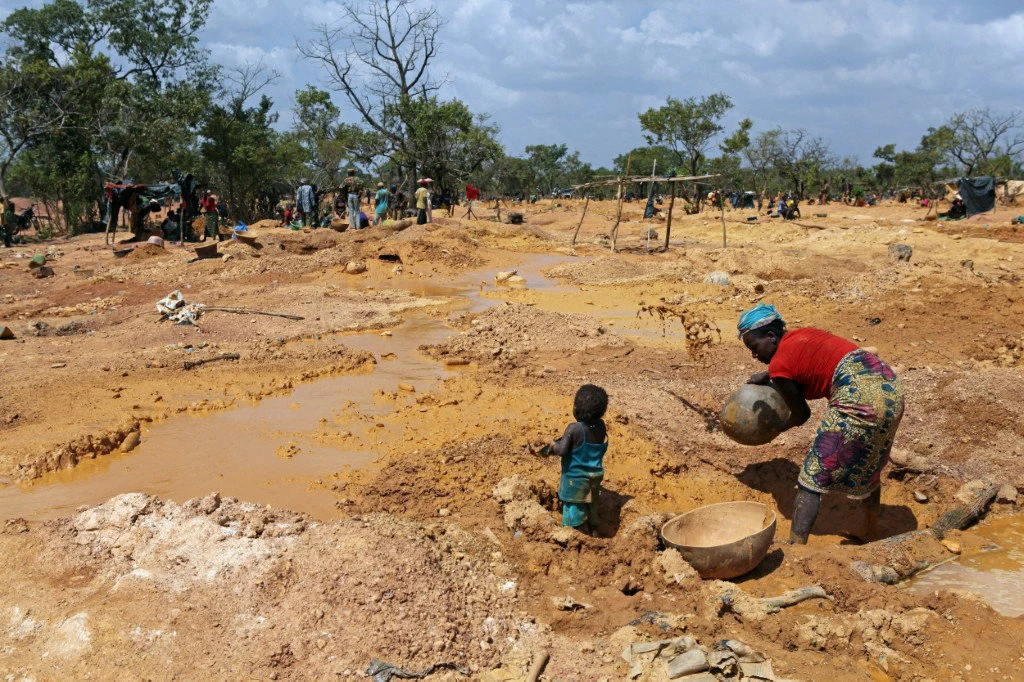 A woman and her child pan for gold in Koflatie, Mali, on October 28, 2014. Practiced for centuries, traditional gold panning has in recent years increased following the 2012 Tuareg rebellion, attracting many unemployed Malians to take to gold prospecting in the west of the country. (AFP file photo)