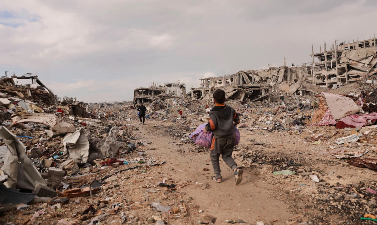 A Palestinian boy carries his belongings as he walks with his family in Gaza City, Gaza Strip, Jan. 24, 2025. (AP)