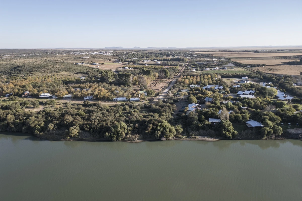 This aerial view shows agricultural land (R), the Orange River and Orania, on May 26, 2024 (AFP)